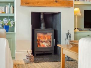 a fireplace in a living room with a stove at Windover Barn in Slinfold