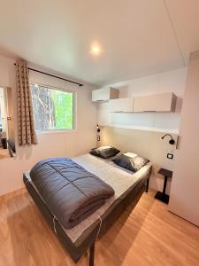 a bedroom with a large bed and a window at Camping Parc Bellevue in Cannes