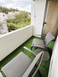 two chairs sitting on a balcony with a window at Coastal Blue Apt 7 in Flic-en-Flac