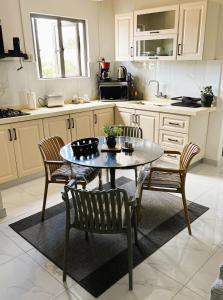 a kitchen with a table and chairs in a kitchen at Coastal Blue Apt 7 in Flic-en-Flac
