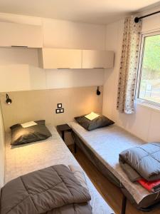 two beds in a room with a window at Camping Parc Bellevue in Cannes +44 photos