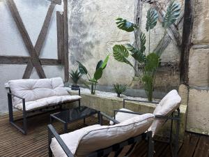 a patio with two chairs and a table and plants at Maison Coursarlon in Bourges