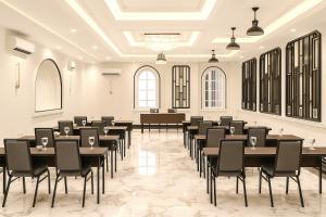 にあるSwiss-Belexpress Paluのテーブルと椅子が置かれた広い部屋