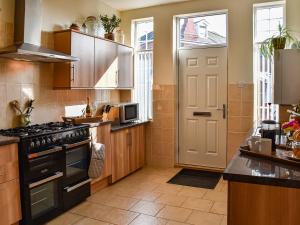 a kitchen with a stove top oven next to a door at St Judes in Mundesley