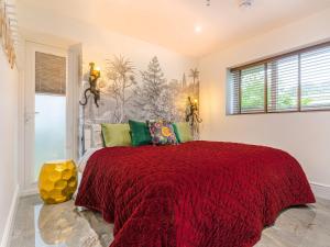 a bedroom with a large bed with a red blanket at The Aviary-Uk44382 in Callington +7 photos