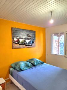 a bedroom with a bed and a painting on the wall at L'Orange Volcanique in Saint-Pierre