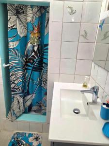 a bathroom with a sink and a blue and white wall at L'Orange Volcanique in Saint-Pierre