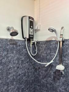 Un teléfono y un secador de pelo en la pared en The Travellers Rest, en Katunayake