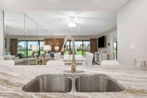 a kitchen with a sink and a living room at Mermaid's Den in Panama City Beach