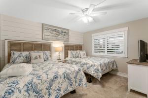 a bedroom with two beds and a ceiling fan at Mermaid's Den in Panama City Beach +90 photos