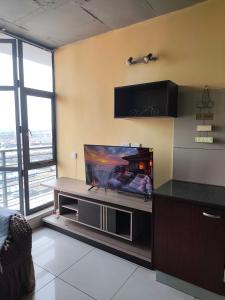 a living room with a flat screen tv on a wall at Broadway flats Braamfontain in Johannesburg