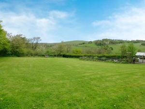ein großes Feld mit grünem Gras und einem Haus im Hintergrund in der Unterkunft Owl Cotes Cottage in Cowling