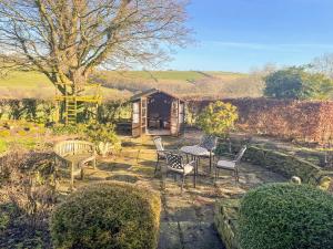 einen Tisch und Stühle vor einer Hütte in der Unterkunft Owl Cotes Cottage in Cowling + 2 Fotos