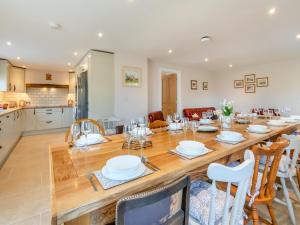 comedor y cocina con mesa de madera grande y sillas en Llwyncelyn Farmhouse, en Clynderwen