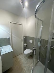 a bathroom with a shower and a toilet and a sink at L'Annexe in Pontchâteau