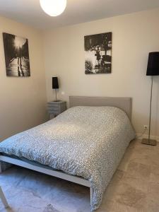 a bedroom with a bed and two pictures on the wall at L'Annexe in Pontchâteau