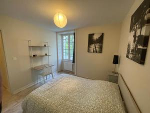 a bedroom with a bed and a table and a lamp at L'Annexe in Pontchâteau