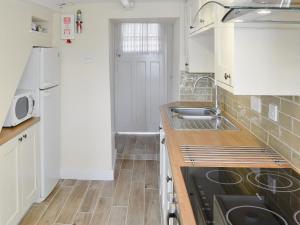 a kitchen with white cabinets and a sink at Gwel An Porth in Charlestown