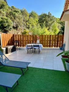 a patio with a table and chairs and a fence at l’Anita in Théoule-sur-Mer