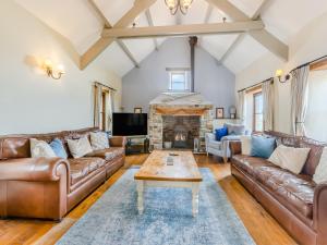 a living room with leather furniture and a fireplace at Atlantic House in Bideford