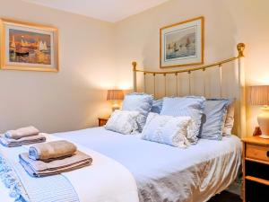 ein Schlafzimmer mit einem großen weißen Bett mit blauen Kissen in der Unterkunft The Old Foundry Holiday Cottage in Burgh le Marsh