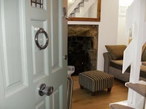 a door leading to a living room with a fireplace at Salty Cottage in Newlyn