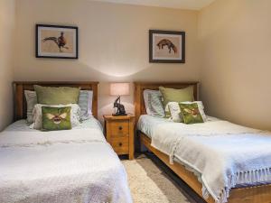 ein Schlafzimmer mit 2 Betten und einer Lampe auf einem Nachttisch in der Unterkunft The Old Foundry Holiday Cottage in Burgh le Marsh + 6 Fotos