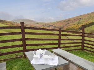 a table with two cups and a tea set on it at Willow Cottage in Ambleside