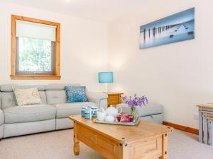 Una sala de estar con un sofá y una mesa de café. en Glen View Of Enrick House, en Bearnock