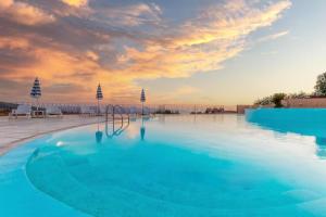 ein großer Pool mit Sonnenuntergang im Hintergrund in der Unterkunft Casa vacanza - Ambra's Homes in Trinità dʼAgultu