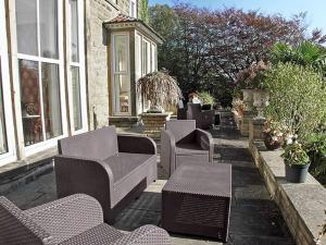 un patio avec des chaises et des tables et une fontaine dans l'établissement Moorlands Cottage, à Levisham 3 autres photos