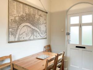 a dining room with a wooden table and a map on the wall at Station House in Hornsea