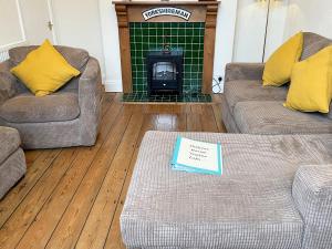 a living room with two couches and a fireplace at Station House in Hornsea