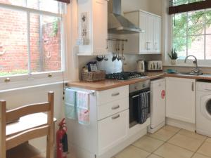 a kitchen with white cabinets and a stove top oven at Station House in Hornsea