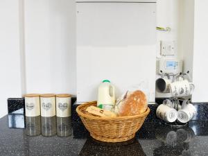 un panier de pain et d'autres articles sur un comptoir dans l'établissement Fallow Cottage - Uk33488, à Hadleigh