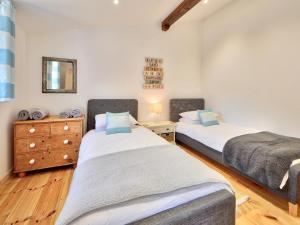 a bedroom with two beds and a dresser and a mirror at Dornfelder - Ukc3209 in Newbridge +9 photos