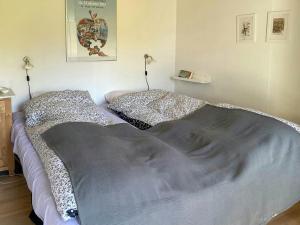 ein Schlafzimmer mit einem Bett mit einer Decke und Kissen in der Unterkunft Family House With Large Garden Near Ebeltoft in Ebeltoft