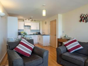 ein Wohnzimmer mit 2 Sofas und einer Küche in der Unterkunft 8 Belvedere Court in Paignton