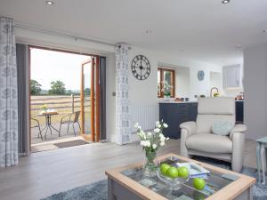 a living room with a chair and a table at The Linhay in Durleigh