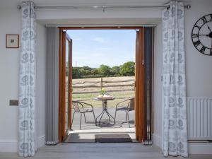 a door leading to a patio with a table and chairs at The Linhay in Durleigh