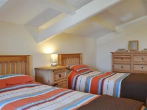 a bedroom with two beds and a dresser at Penrhyn Mawr - Hw7642 in Aberdaron +4 photos