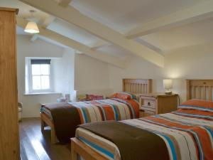 a room with three beds and a window at Penrhyn Mawr - Hw7642 in Aberdaron