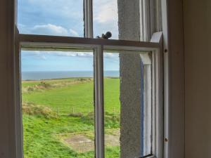 an open window with a view of a green field at Penrhyn Mawr - Hw7642 in Aberdaron