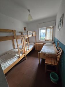 a room with two bunk beds and a window at Wax Hostel in Faro