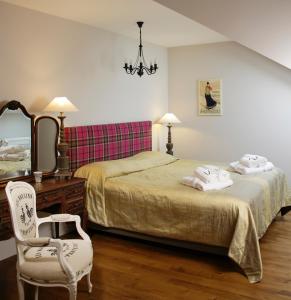 een slaapkamer met 2 bedden, een stoel en een spiegel bij Lemon Apartments in Krynica Zdrój