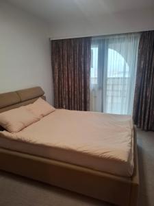un letto in una camera da letto con una grande finestra di Promenada Wiew a Craiova