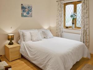 a bedroom with a white bed and a window at Willow Cottage - E4778 in Atwick
