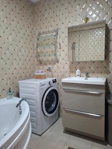 un bagno con lavatrice e lavandino di Promenada Wiew a Craiova