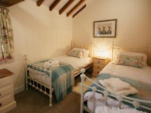 ein Schlafzimmer mit zwei Betten und einer Kommode in der Unterkunft Granary Cottage - E5626 in Wainfleet All Saints
