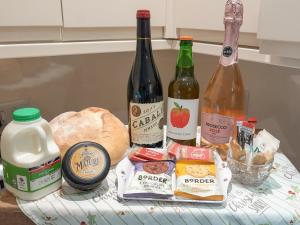 ein Tisch mit Weinflaschen und Brot in der Unterkunft The Lodge At Forbury Cottage in Kimbolton